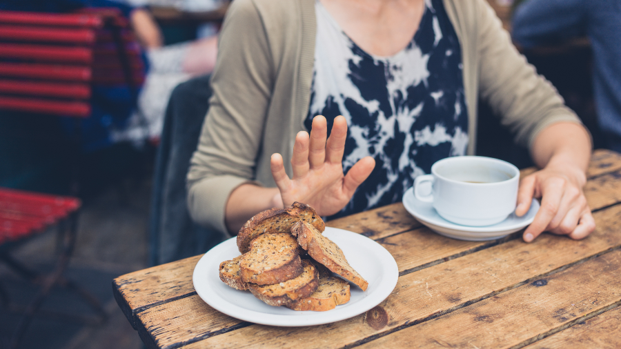A woman refusing bread at a cafe due to a gluten intolerance 