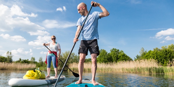 man and woman paddle boarding