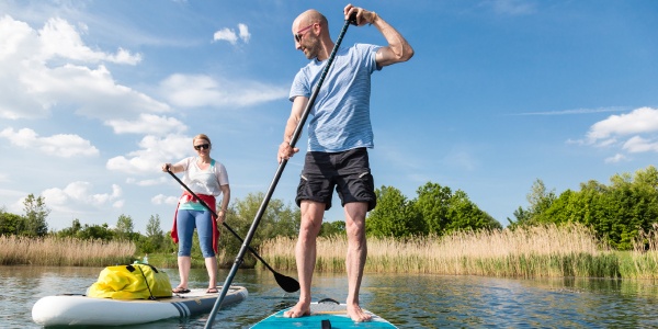 man and woman paddle boarding