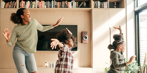 woman and two young girls dancing in family room