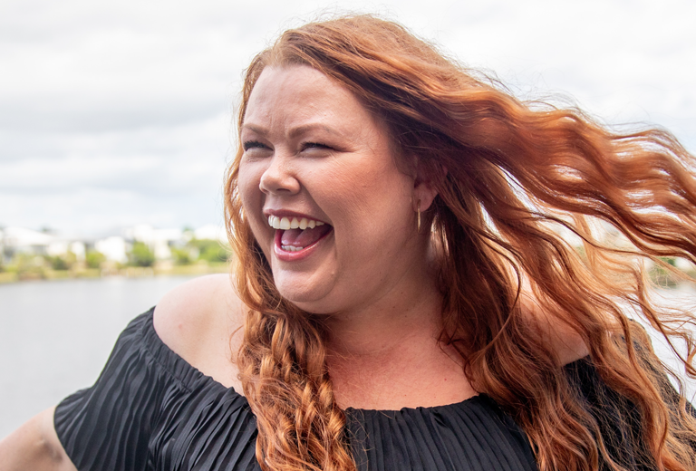 woman smiling with hair blowing in the wind