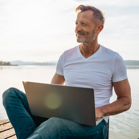 man on beach with laptop