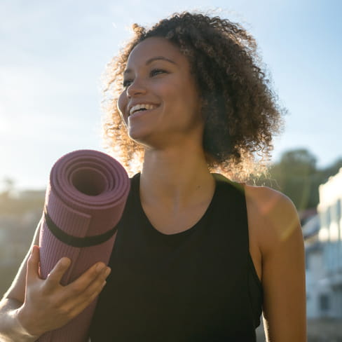 woman holding a yoga mat