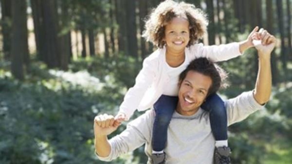 father carrying daughter on shoulders
