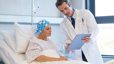 An oncologist goes over blood test results with his patient.