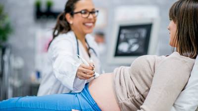 Doctor performs ultrasound on pregnant woman